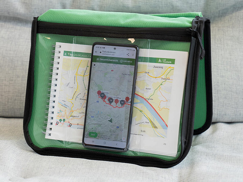 Smartphone und Routenbuch in der Lenkertasche