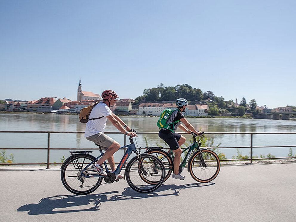 Zwei Radfahrer am Innufer gegenüber von Schärding