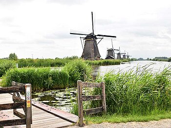 Windmühlen am Ufer eines Flusses