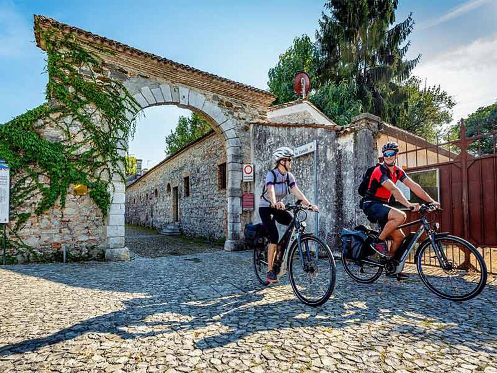 2 Radfahrer am gepflasterten Platz