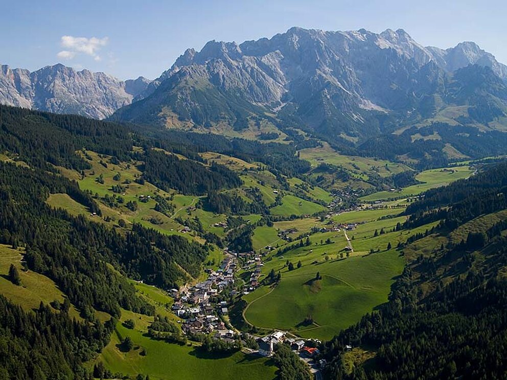 Flugaufnahme vom Ort, im Hintergrund Berge