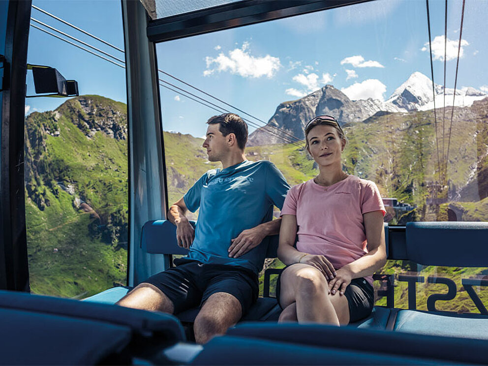ein Paar sitzt in der Gondel auf das Kitzsteinhorn.