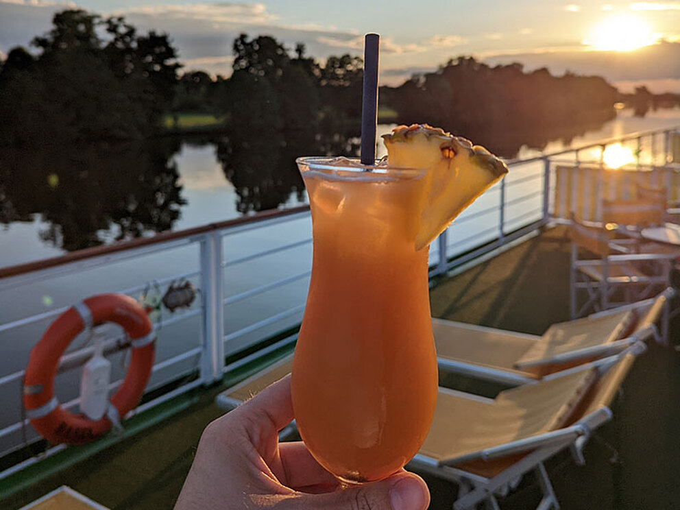 Cocktail mit Schirmchen an Deck eines Schiffes