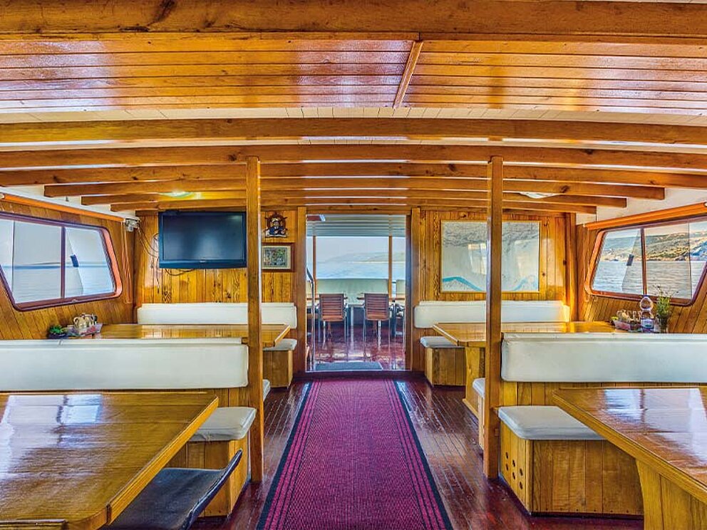 Saloon des Schiffes mit gemütlichen Tischen mit Bänken und Fernseher