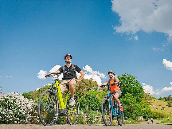2 Radfahrer am asphaltierten Radweg mit E-Bikes