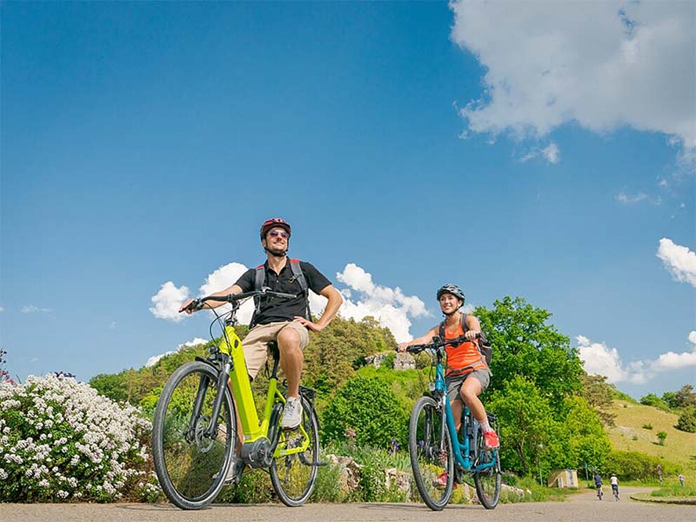 2 Radfahrer am asphaltierten Radweg mit E-Bikes