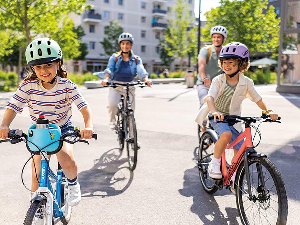 Eine Familie mit 2 Kindern unterwegs auf ihren Rädern.