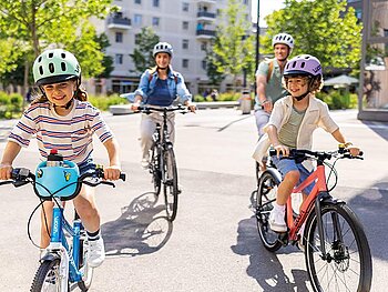 Eine Familie mit 2 Kindern unterwegs auf ihren Rädern.