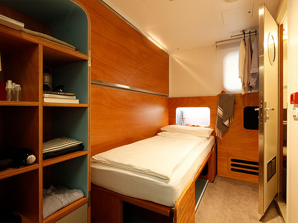 Einzelbett, kleiner offener Schrank