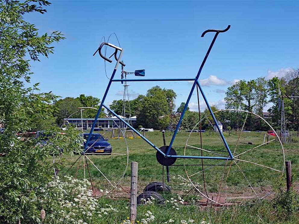 ein großes Fahrrad aus Draht auf einer Wiese