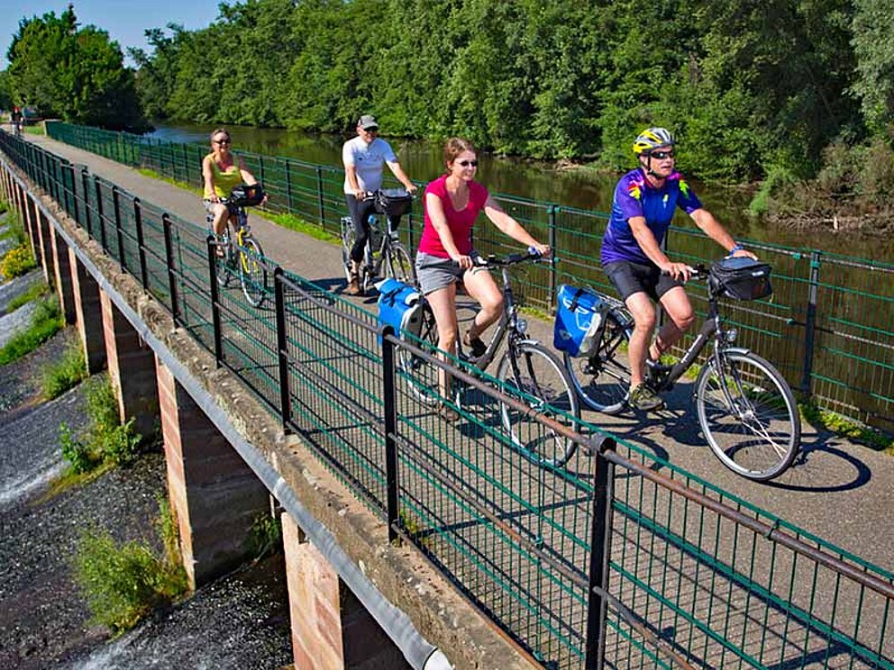 4 Radfahrer auf einer Brücke