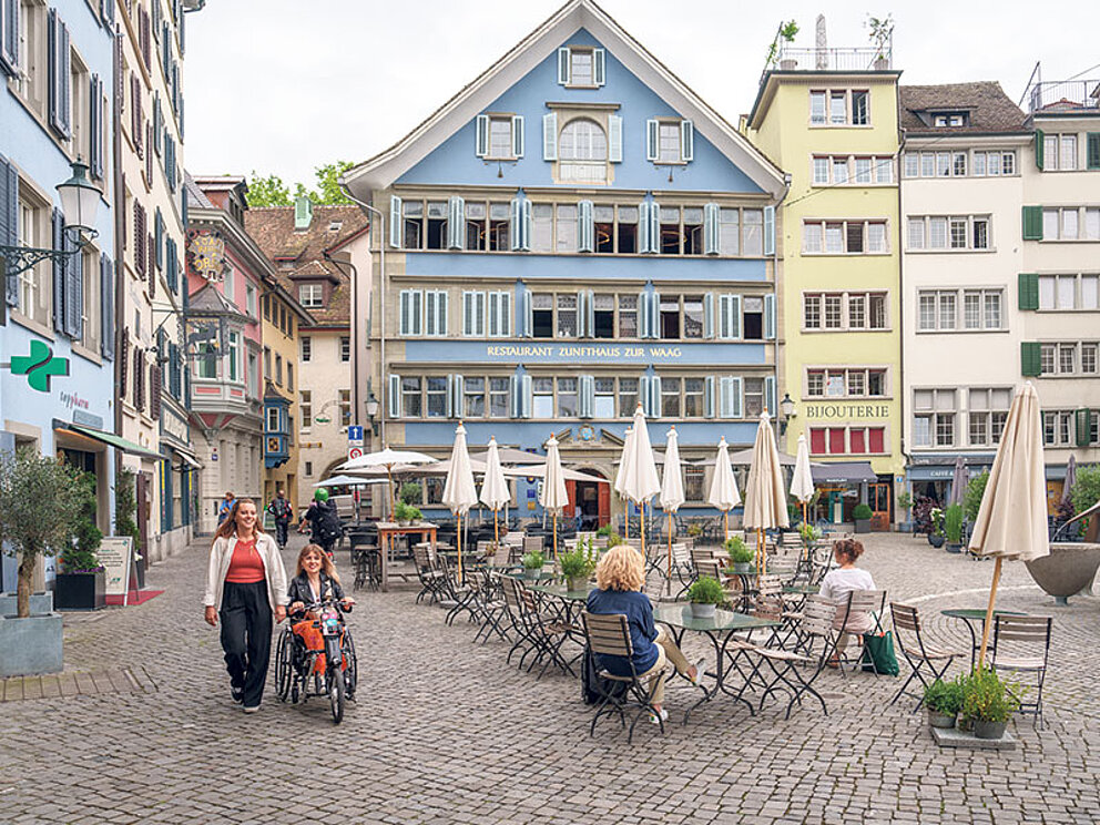der geplasterte Münsterplatz in Zürich mit bunten Häusern und Outdoor-Cafés