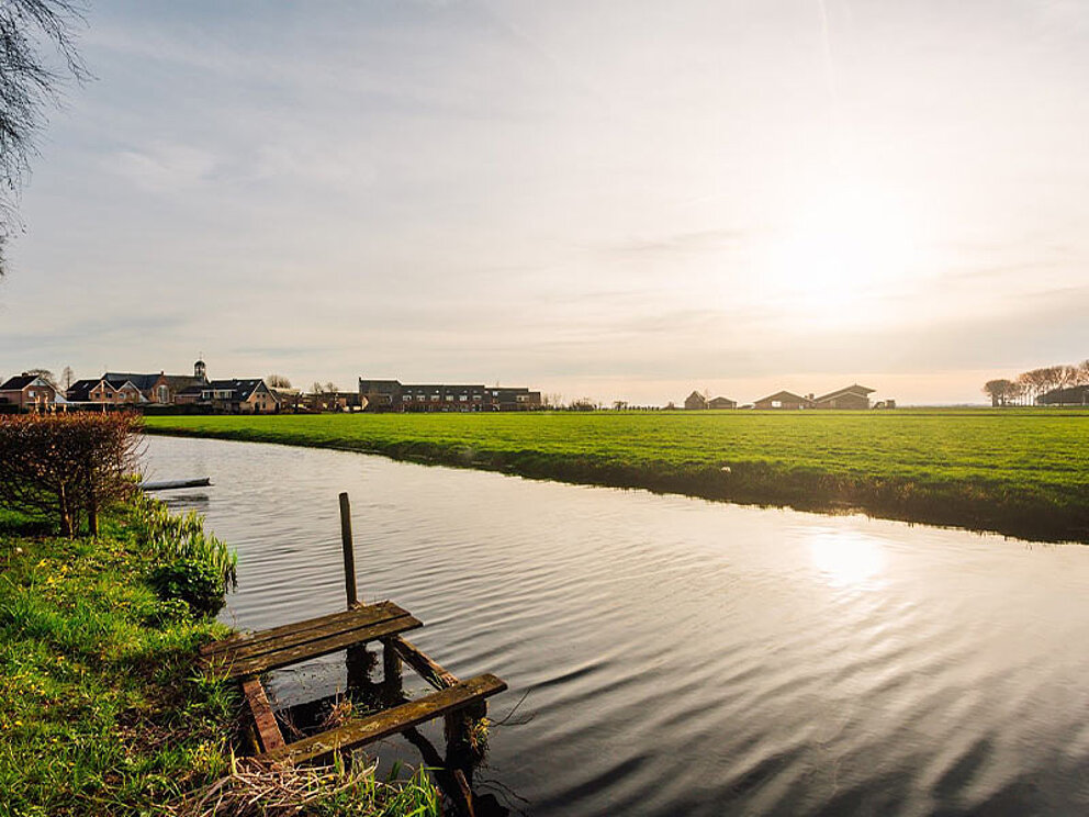 ein Fluss mit grünen Wiesen im Umland