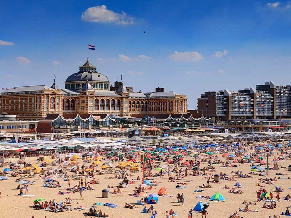 gut gefüllter Sandstrand von Scheveningen, im Hintergrund die Stadt