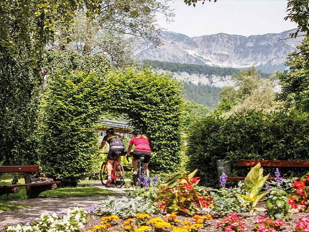 2 Gravelbiker radeln durch den herbstlichen Kurpark in Bad Goisern