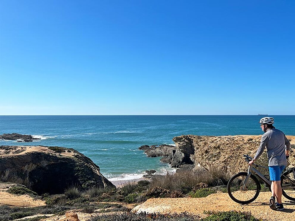 ein Radfahrer blickt auf das Meer