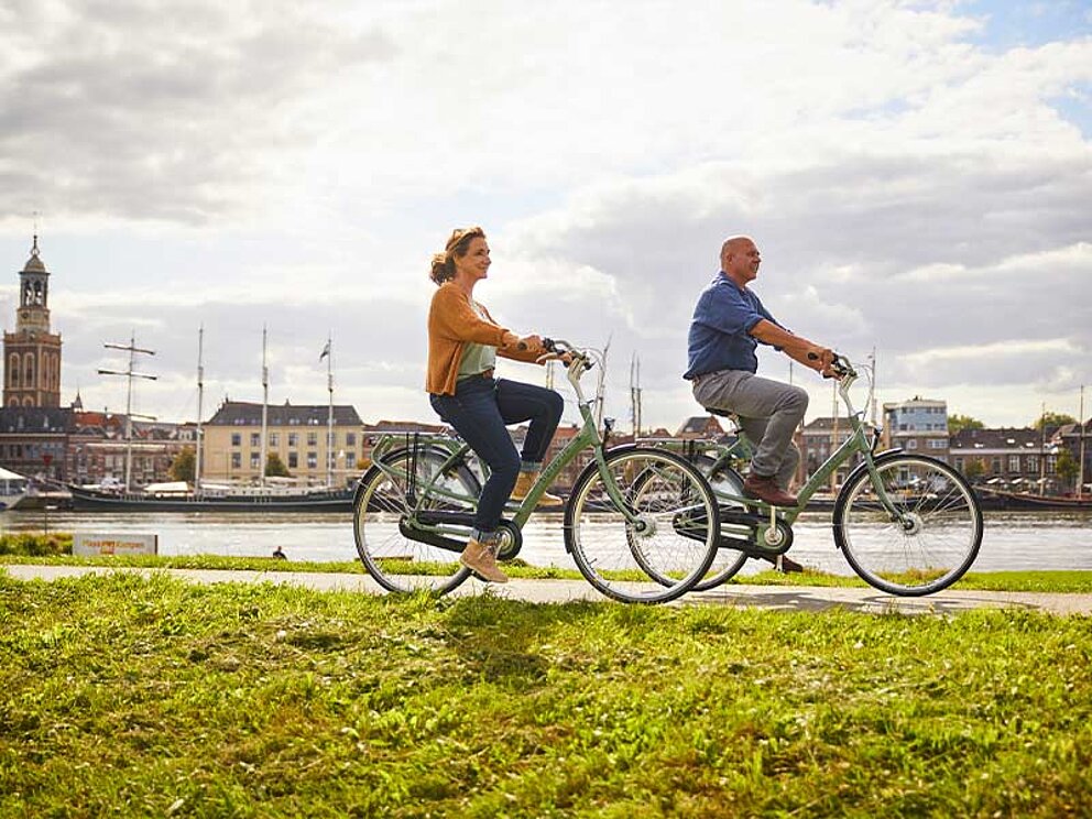 2 Radfahrer am Ufer eines Flusses