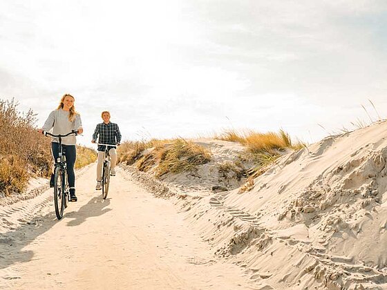 Mann und Frau radeln durch die Dünen auf Hiddensee