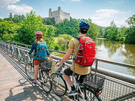 2 Radfahrer von hinten, an ein Brückengeländer gelehnt. Im Hintergrund die Willibaldburg.