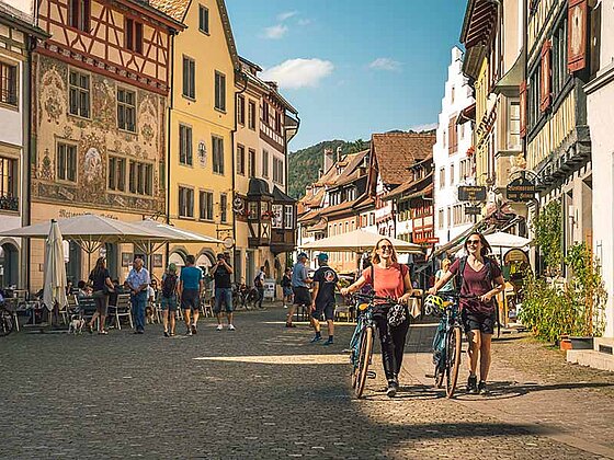 2 Damen schieben ihr Rad durch eine Gasse in Stein am Rhein