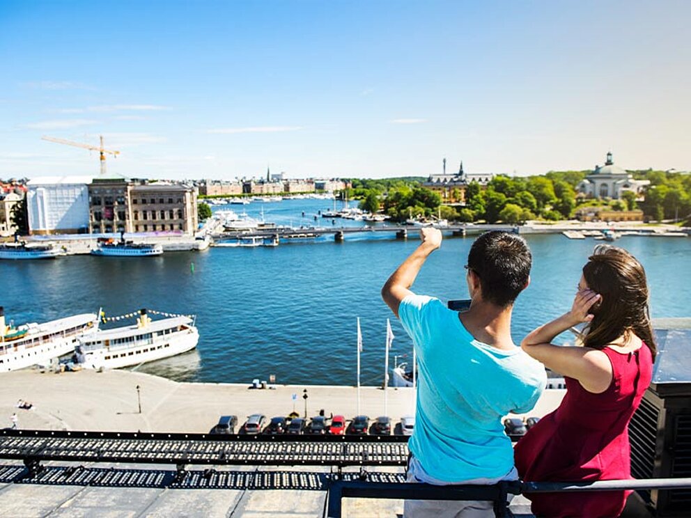 ein Paar blickt von einem Hochhaus über Stockholm