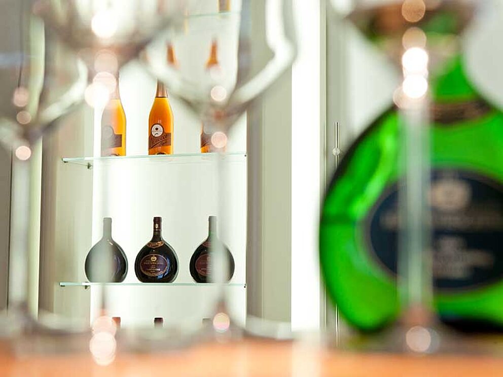 mehrere ellipsoide Bocksbeutel Flaschen mit Frankenwein und Weingläser