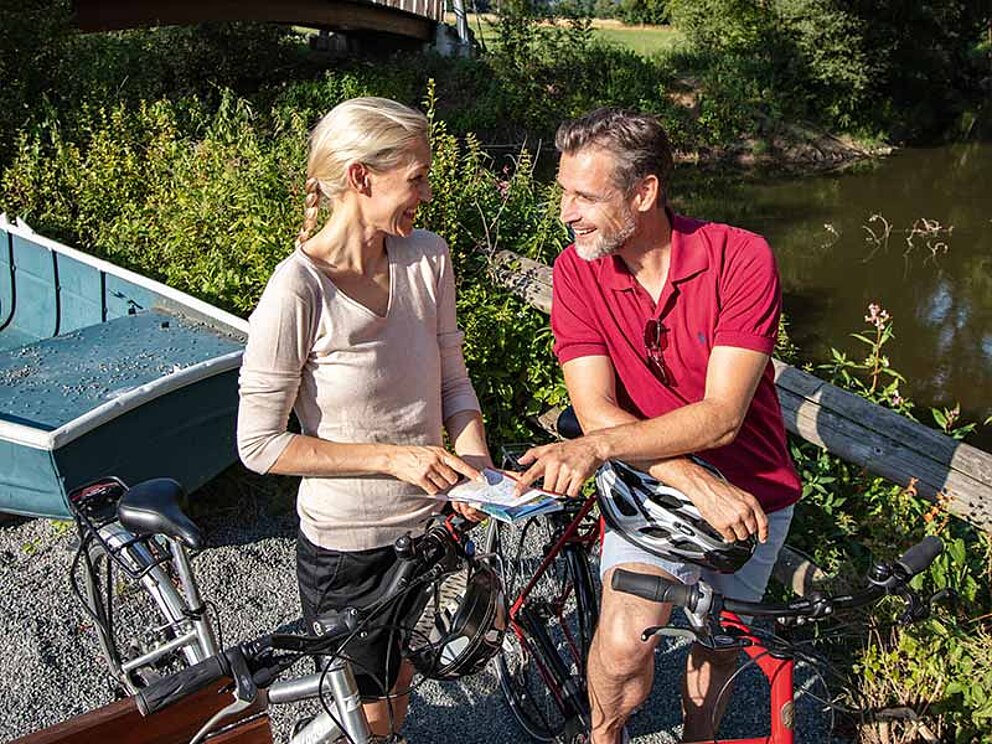 1 Paar mit Fahrrädern studiert die Karte