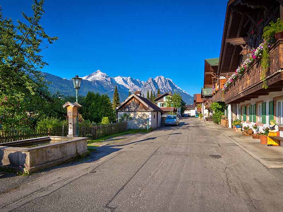 historische Frühlingsstraße mit typischen Häusern in Garmisch-Partenkirchen am Isarradweg
