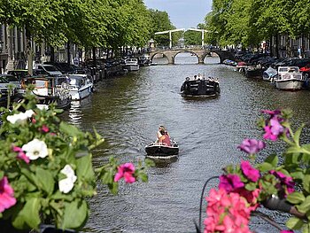 Blick von Brücke auf Kanal mit Booten in Amsterdam