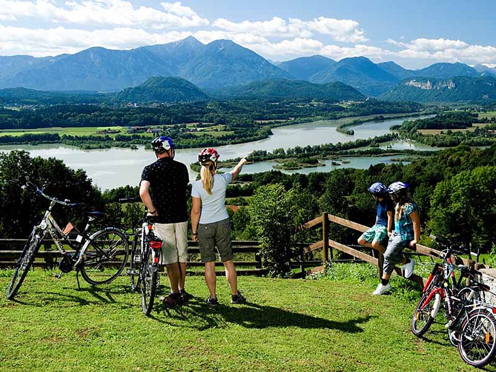 Radfahrer-Familie bewundern den Völkermarkter Stausee am Drauradweg