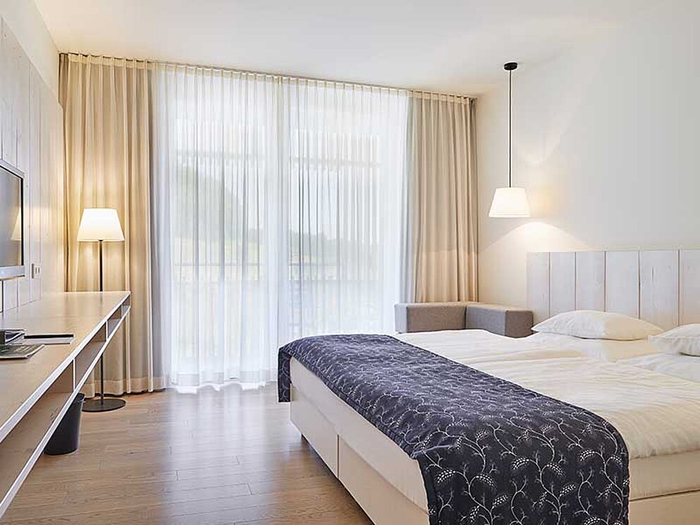 Ein Doppelzimmer mit King-Size-Bett, Flat-TV und eigenem Balkon
