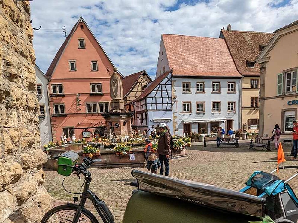 Place St. Leon umgeben von alten Häusern, im Vordergrund Fahrräder