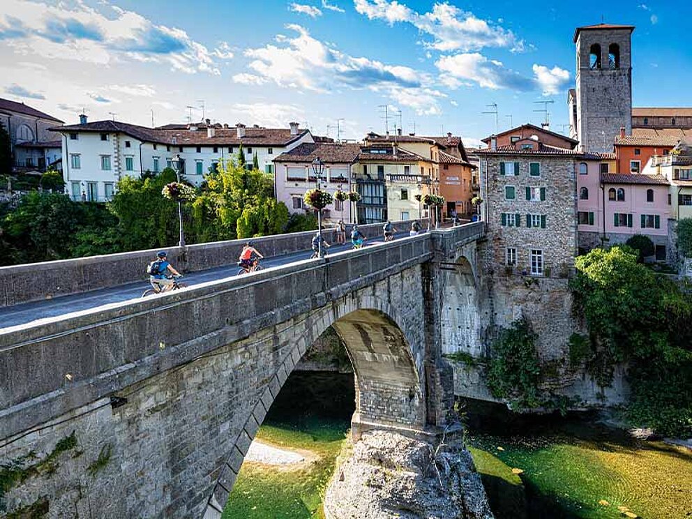 Radfahrer auf einer Brücke vor Udine