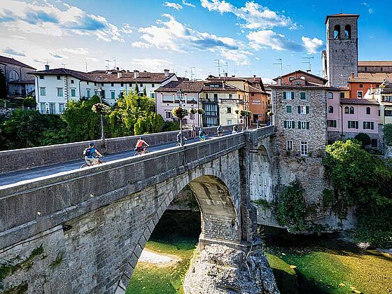 Radfahrer auf einer Brücke vor Udine