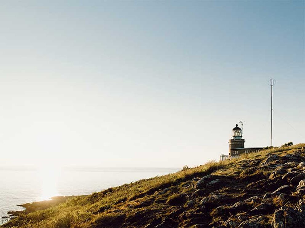 Leuchtturm auf einem Grashügel in Schweden