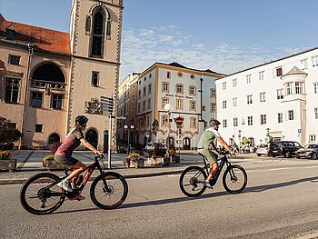 2 Radfahrer fahren durch die Innenstadt von Passau