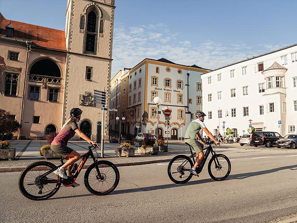 2 Radfahrer fahren durch die Innenstadt von Passau