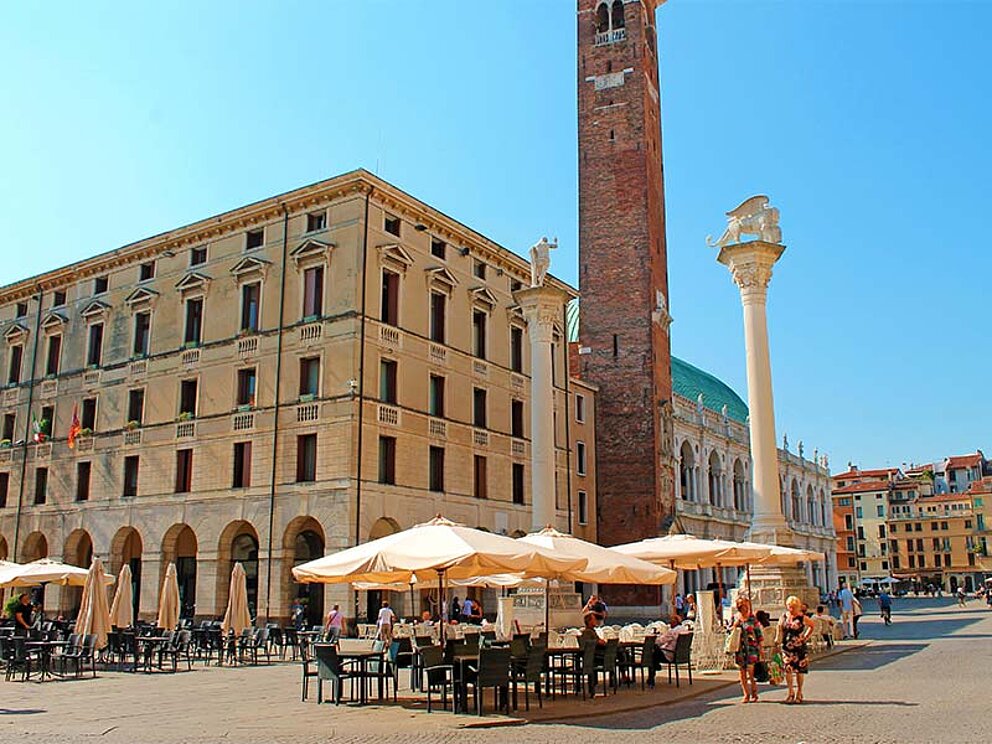 Hauptplatz mit vielen Gastgären mit Schirmen und Tischen