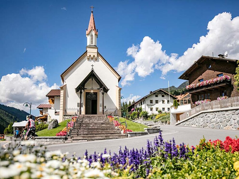 Kapelle von Pettneu, davor ein Blumenbeet