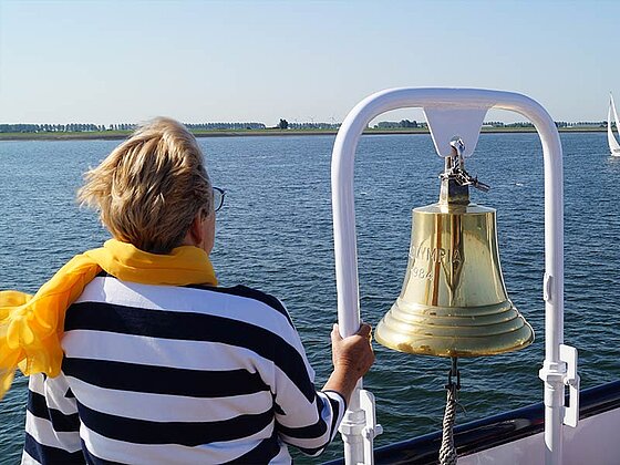eine Dame von hinten bei der Schiffsglocke