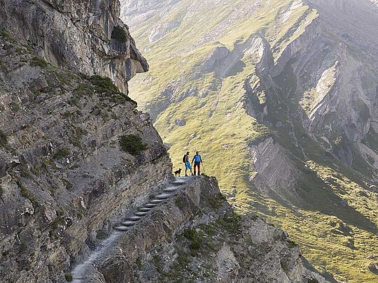 2 Wanderer entlang eines Felsens auf Felsttreppen.