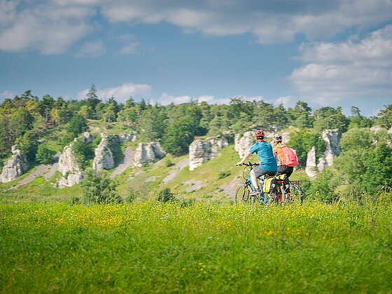 2 Radfahrer von hinten, im Hintergrund Felsen
