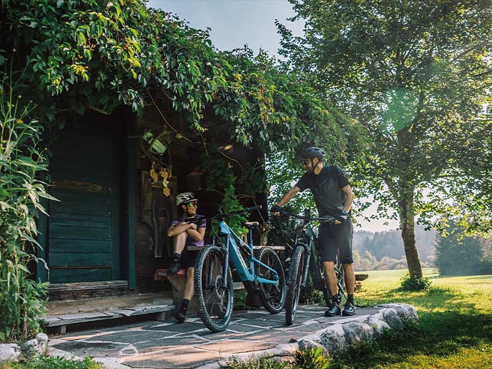 ein Paar sitzt vor einer Hütte im Salzkammergut.