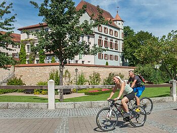 2 Radfahrer fahren am Schloss Treuchtlingen vorbei