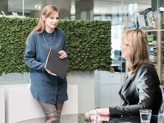 2 Damen unterhalten sich im Büro