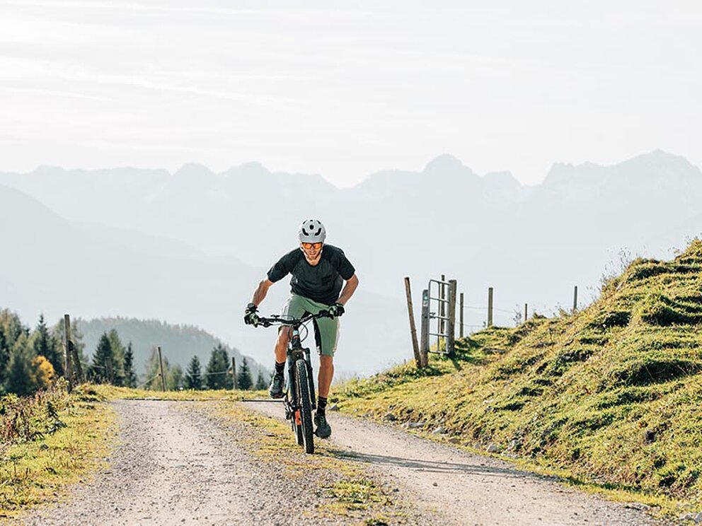 Ein Mountainbiker bei der Auffahrt am Schotterweg in den Kalkalpen