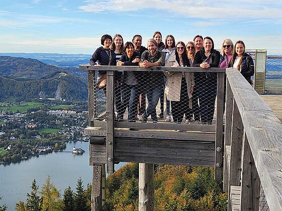 eine Gruppe steht auf einer Plattform, darunter der Traunsee