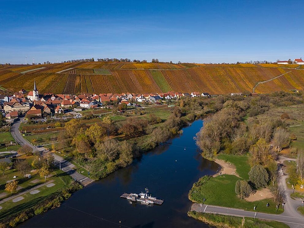 Landschafsbild mit Main und Fähre mitten am Fluss