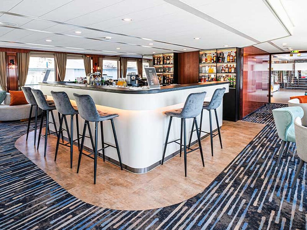 weiße Bar mit Barhockern in der Lounge am Bord der MS Vivienne