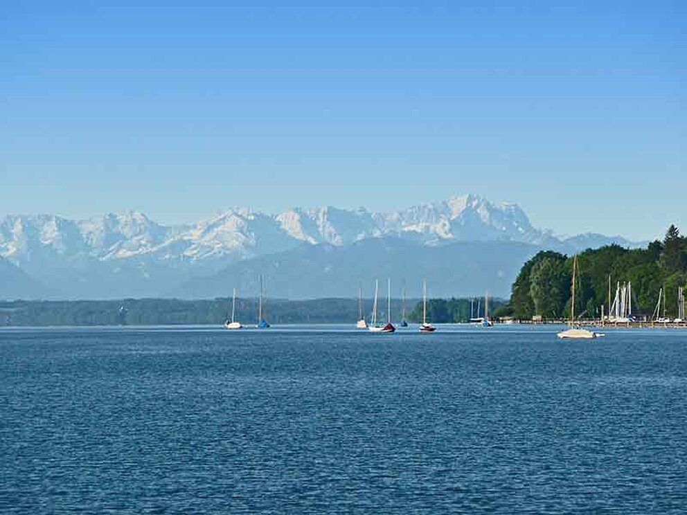 Blick auf den See mit Segelbooten und Bergen